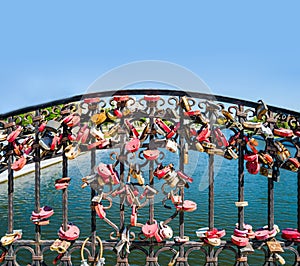 Many love locks hanging on some bridge, copyspace on lear sky. Long term relationship symbol