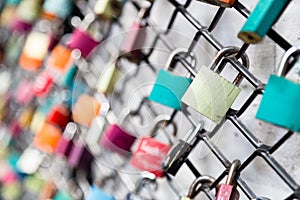 Many love padlocks on fence concept with selective focus on a blank lock at foreground