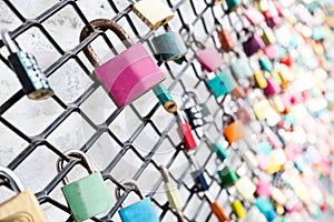 Many love padlocks on fence concept with selective focus on a blank lock at foreground