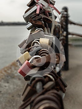 Many love padlocks locked on iron chain with perspective