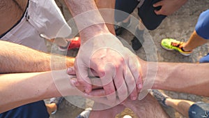 Many male hands getting together. Team of athletes putting arms together outdoor. Group of people joining hands together