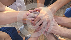 Many male hands getting together. Team of athletes putting arms together outdoor. Group of people joining hands together