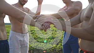 Many male hands getting together. Team of athletes putting arms together outdoor. Group of people joining hands together