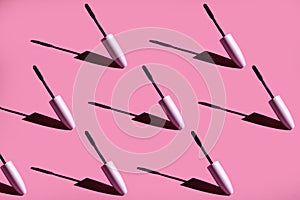 many mascara brushes on a pink photo