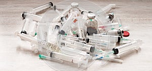 Many medicine bottles, ampules, vials, injection needles and syringes stack together on white background