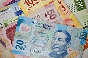 Mexican pesos bills spread randomly over a flat surface
