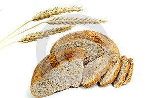 Many mixed breads and rolls of baked bread on isolated white background. ears of wheat.