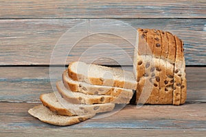 Many mixed breads and rolls of baked bread on wooden table background.