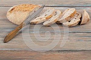 Many mixed breads and rolls of baked bread on wooden table background.