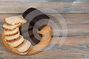 Many mixed breads and rolls of baked bread on wooden table background.