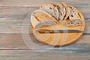 Many mixed breads and rolls of baked bread on wooden table background.