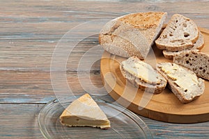 Many mixed breads and rolls of baked bread on wooden table background.