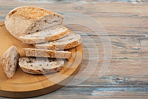 Many mixed breads and rolls of baked bread on wooden table background.