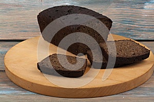 Many mixed breads and rolls of baked bread on wooden table background.