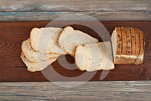 Many mixed breads and rolls of baked bread on wooden table background. Top view