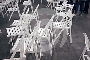 Many mixed white plane chairs on the grey floor