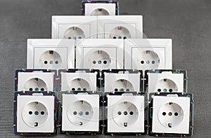 Many modern electrical sockets on a gray background, close-up. Rise in the price of electricity price per kilowatt