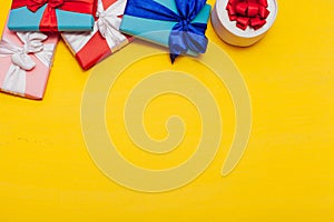 Many multi-colored gifts for the holiday on a yellow background