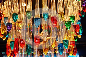 many multi-colored light bulbs in the form of drops hang on the ceiling