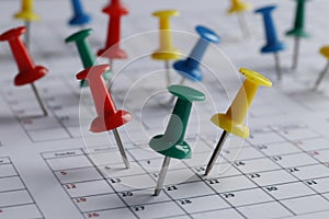 Many multi-colored pins of different dates on a calendar close-up. Important date. Place for text.