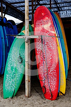 Many multi-colored surfboards in a row