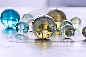 Many multicolored glass balls on a wooden surface.