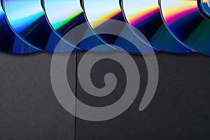 Many musical compact discs with a rainbow spectrum of colors as a bright background