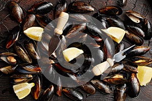 Many mussels with lemon slices in the net, water spray