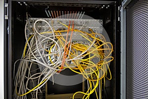 Many network cables are plugged into a server cabinet