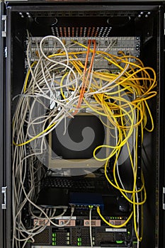 Many network cables are plugged into a server cabinet