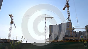 Many new high-rise buildings and cranes over blue sky background.