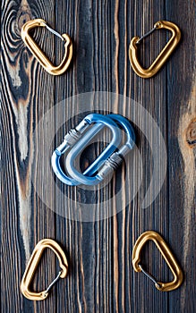 Many of objects. Isolated photo of climbing equipment. Parts of carabiners lying on the wooden table