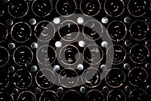 Many old glass dusty champagne bottles, stacked in the wine cellar close up