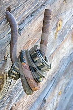 Many old rustic weathered large roller with ball bearing on iron hook, dried out grease and broken bearing. Industrial background