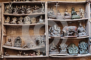 Many old statuettes on wooden shelves