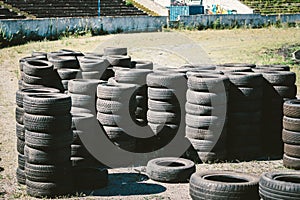 Many old used car tires stacked on top of each other on Automobile sports complex. Industrial landfill for the