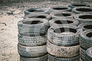 Many old used car tires stacked on top of each other on Automobile sports complex. Industrial landfill for the