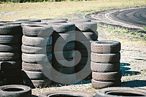 Many old used car tires stacked on top of each other on Automobile sports complex. Industrial landfill for the