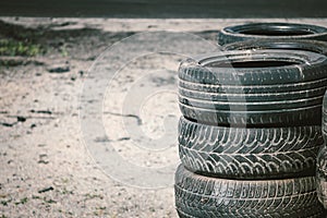 Many old used car tires stacked on top of each other on Automobile sports complex. Industrial landfill for the