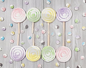 Many Ñolorful meringue lollipop on a grey background