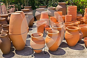 Many orange clay vases outside at pottery