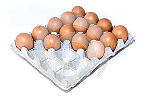 Many orange farm spotted brown chicken eggs in carton open box container on white backdrop