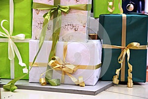 Many Packed boxes with gifts in green, beige and gold colors. large stack of Christmas presents. christmas holidays