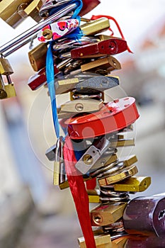 Many padlocks are locked on the bridge railing