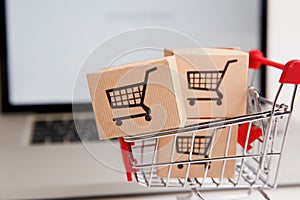 Many paper boxes in a small shopping cart on a laptop keyboard. Concepts about online shopping that consumers can buy