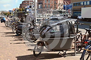 Many parked bikes and bicycles for rent on city street