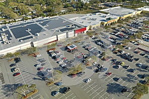 Many parked cars on store parking lot with lines and markings for parking places and directions. Place for vehicles in