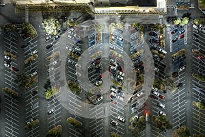 Many parked cars on store parking lot with lines and markings for parking places and directions. Place for vehicles in