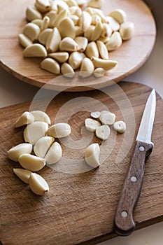 many peeled garlic cloves on wooden cutting boards