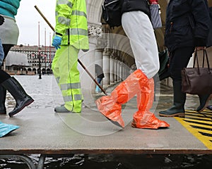 many people on the footbridge with plastic gaiters in Venice in photo